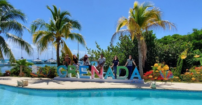 Group photo of students standing with Grenada letters