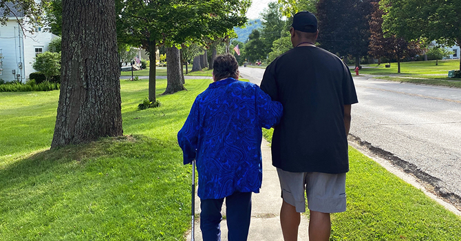 Caregiver supporting a family member on a walk