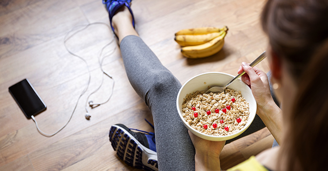 Young adult in athletic wear holding a bowl of oatmeal