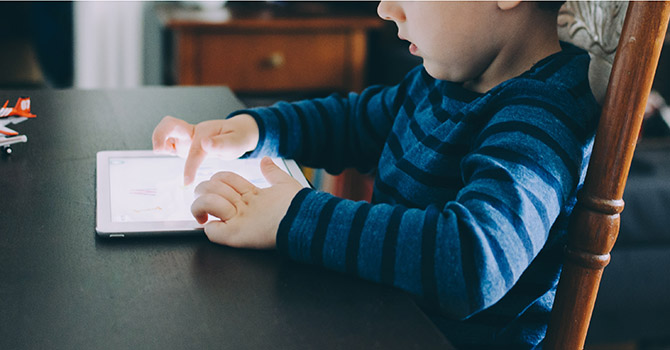 A young child playing on an iPad.