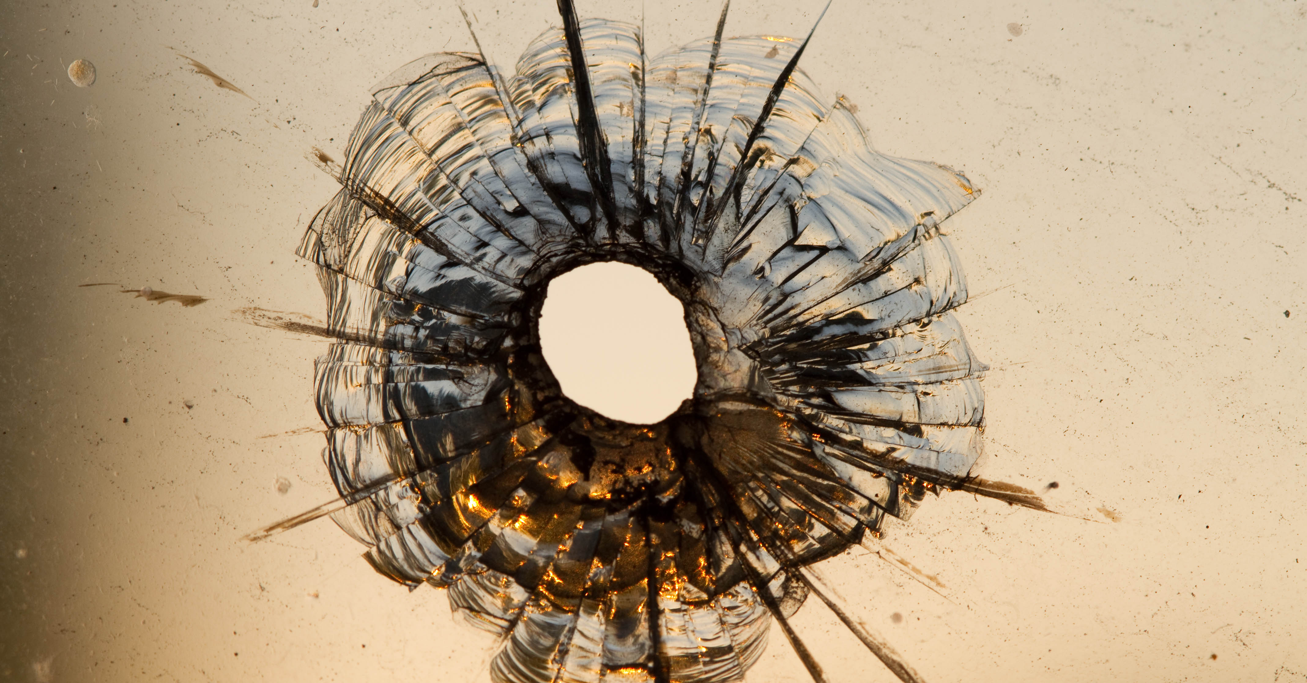 A bullet hole in a glass window.